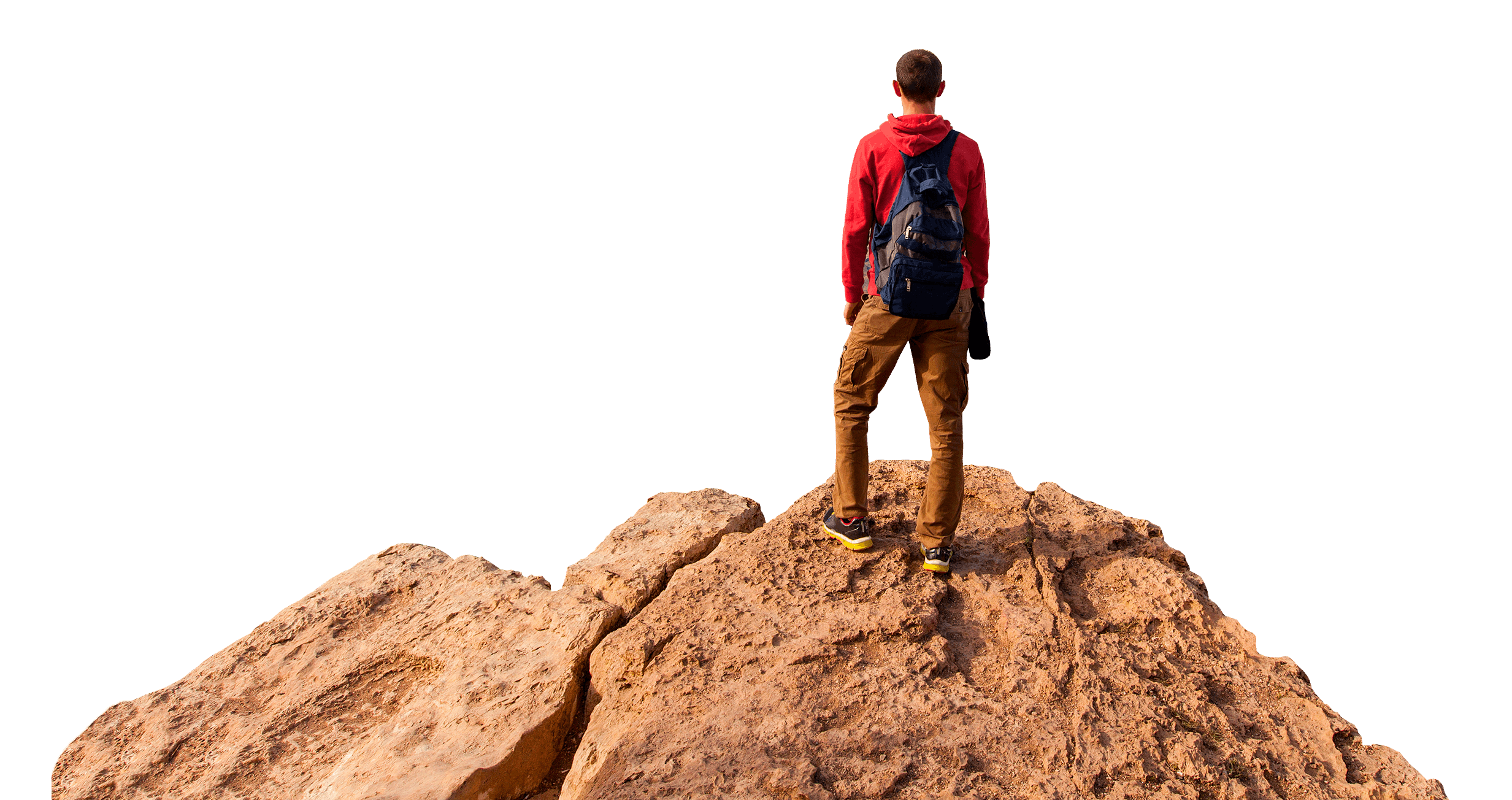 Boy with rucksack standing on a rock looking out